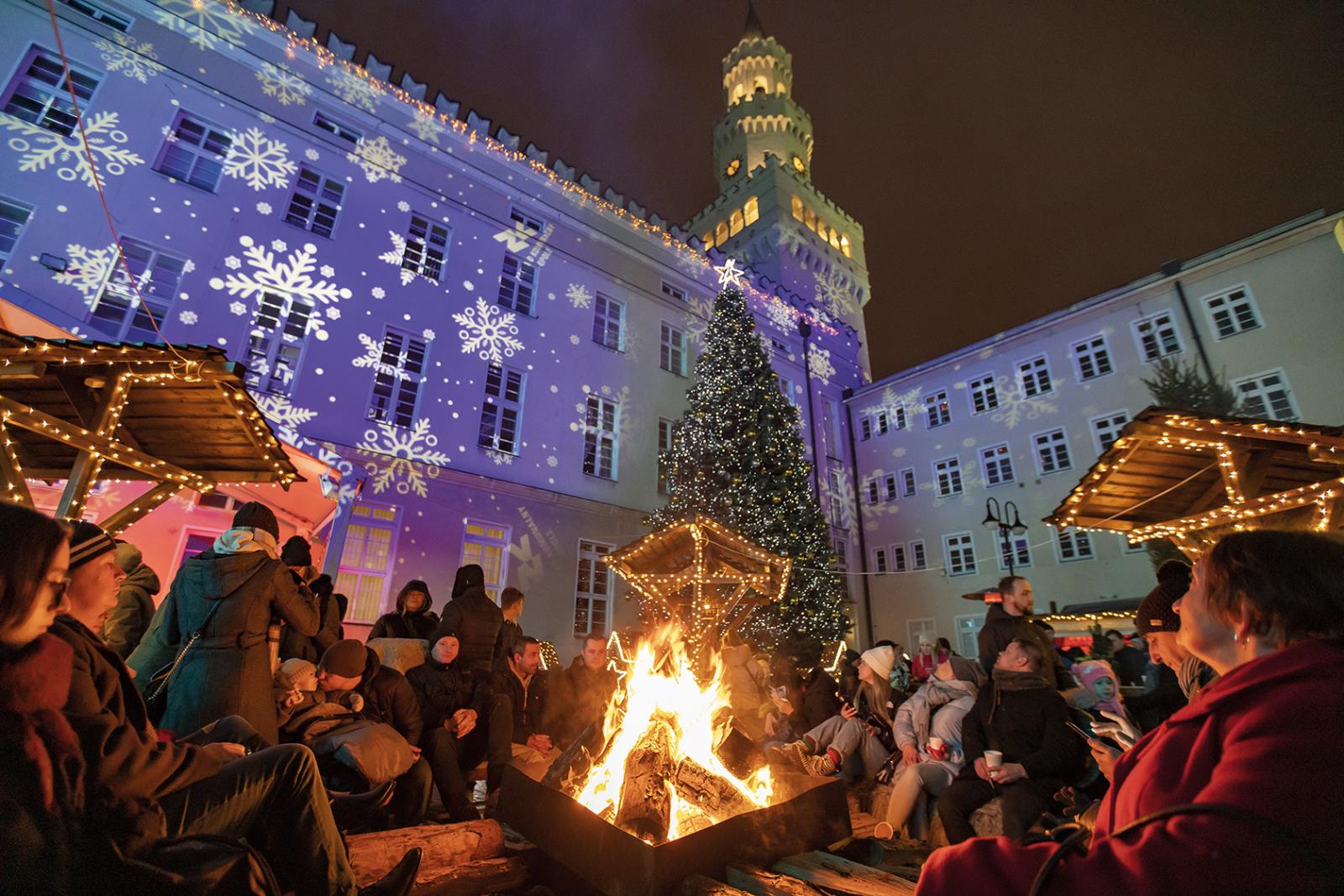 Jarmark Bożonarodzeniowy - ludzie siedzący przy ognisku na rynku w Opolu