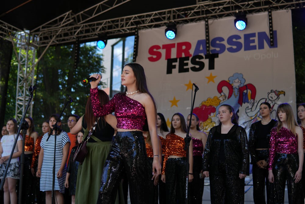 biała kobieta, trzyma mikrofon, śpiewa na scenie