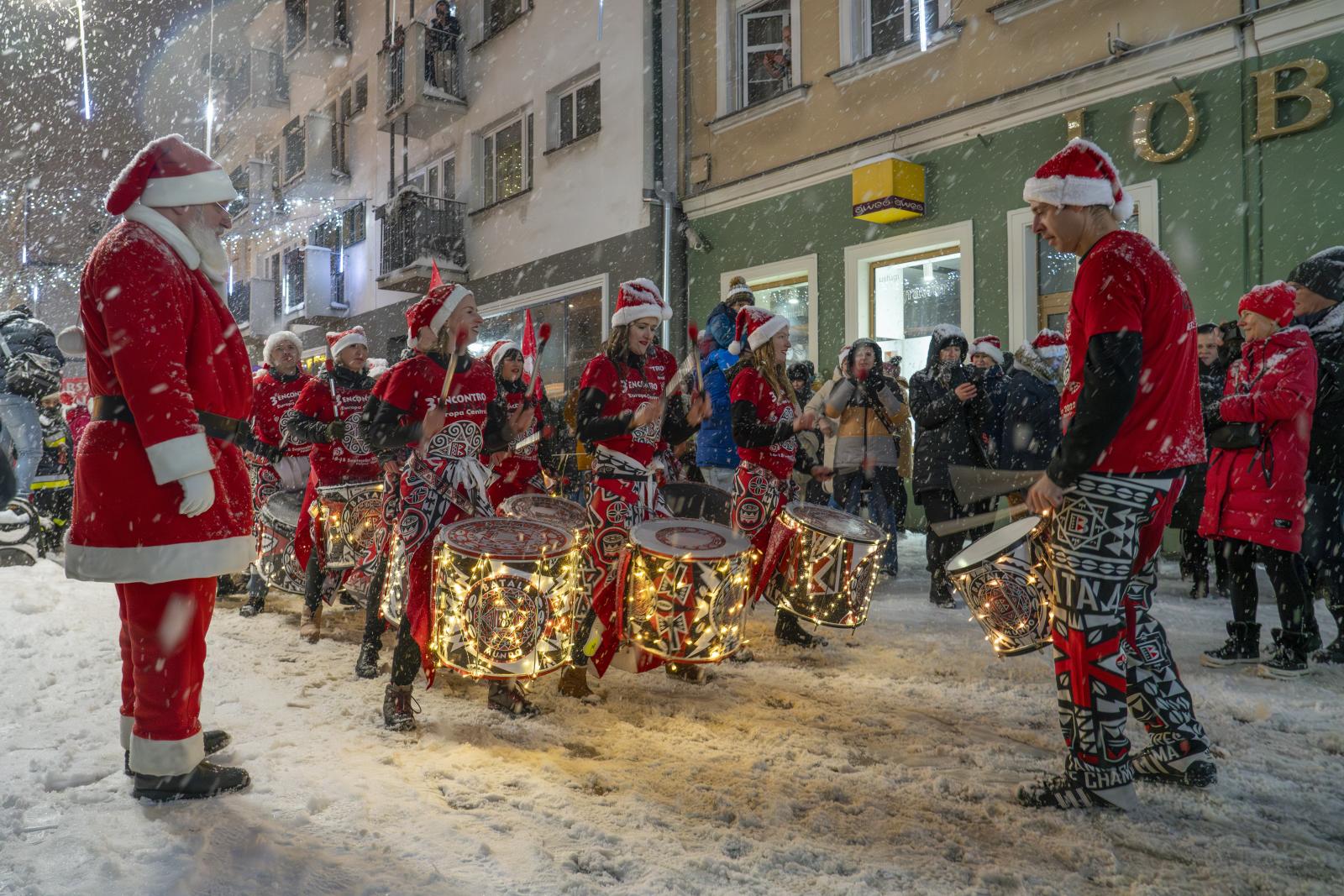 Marsz Mikołajów na ulicy Krakowskiej, gra grupa bębniarzy, pada śnieg