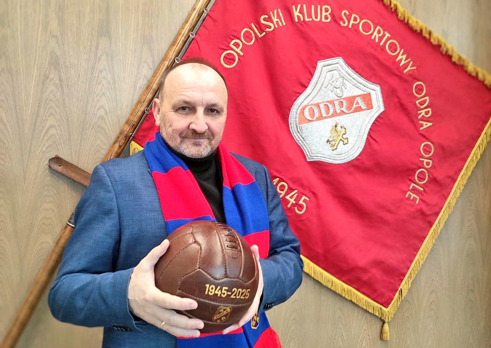 Dariusz Król trzymający piłkę, w tle sztandar Odry