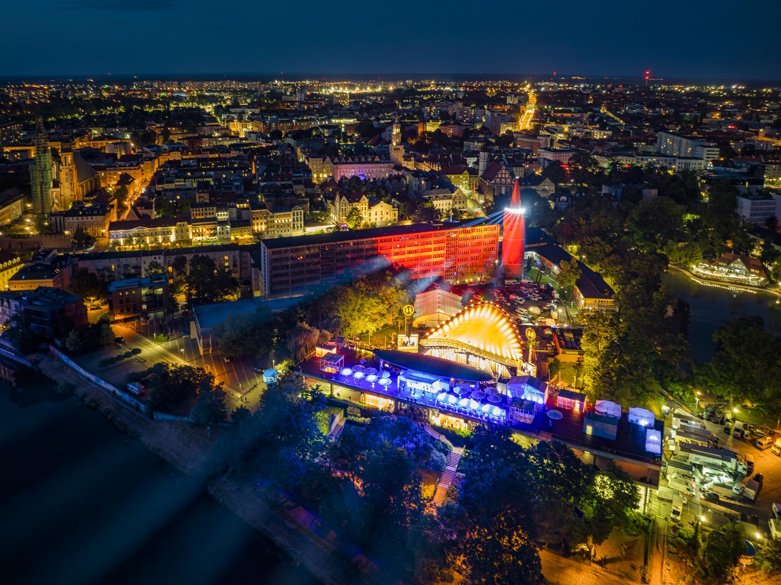 Roświetlony Amfitear podczas Krajowego Festiwalu Polskiej Piosenki w 2023 roku od strony Odry, z widokiem na scene i Wieżę Piastowską