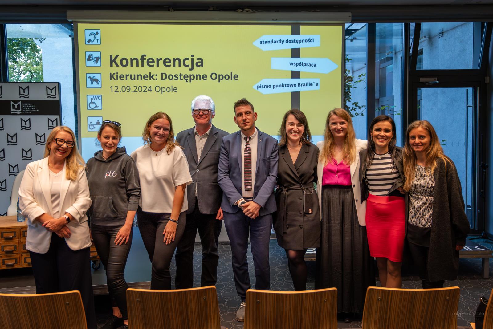 zdjęcie uczestników konferencji, w tle wyświetlany slajd "Konferencja Kierunek: Dostępne Opole"