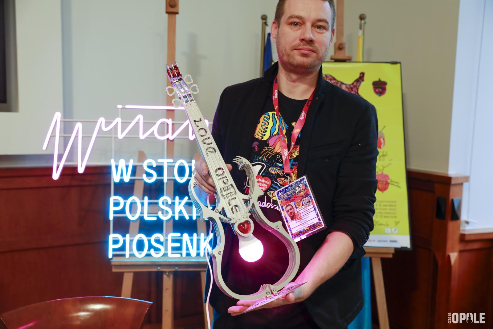 mężczyzna przedstawiający skrzypce - fant na licytację. Fot. Witold Chojnacki