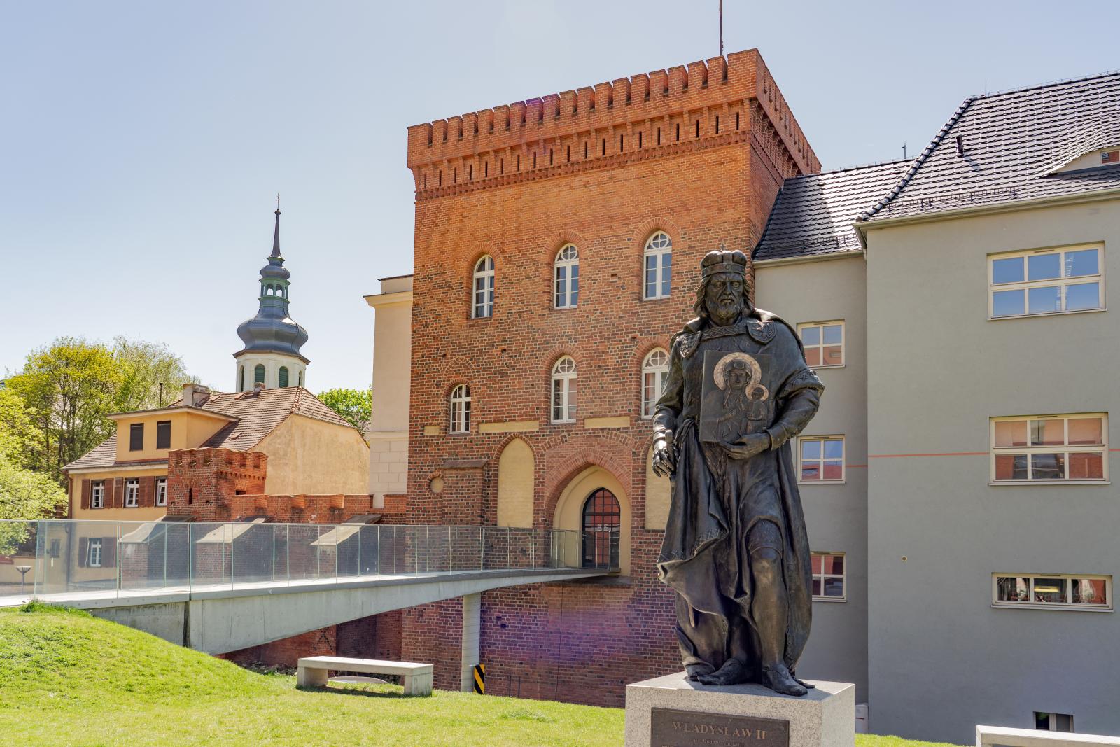 Zdjęcie przedstawia Zamek Górny, na pierwszym planie pomnik Władysława II Opolczyka