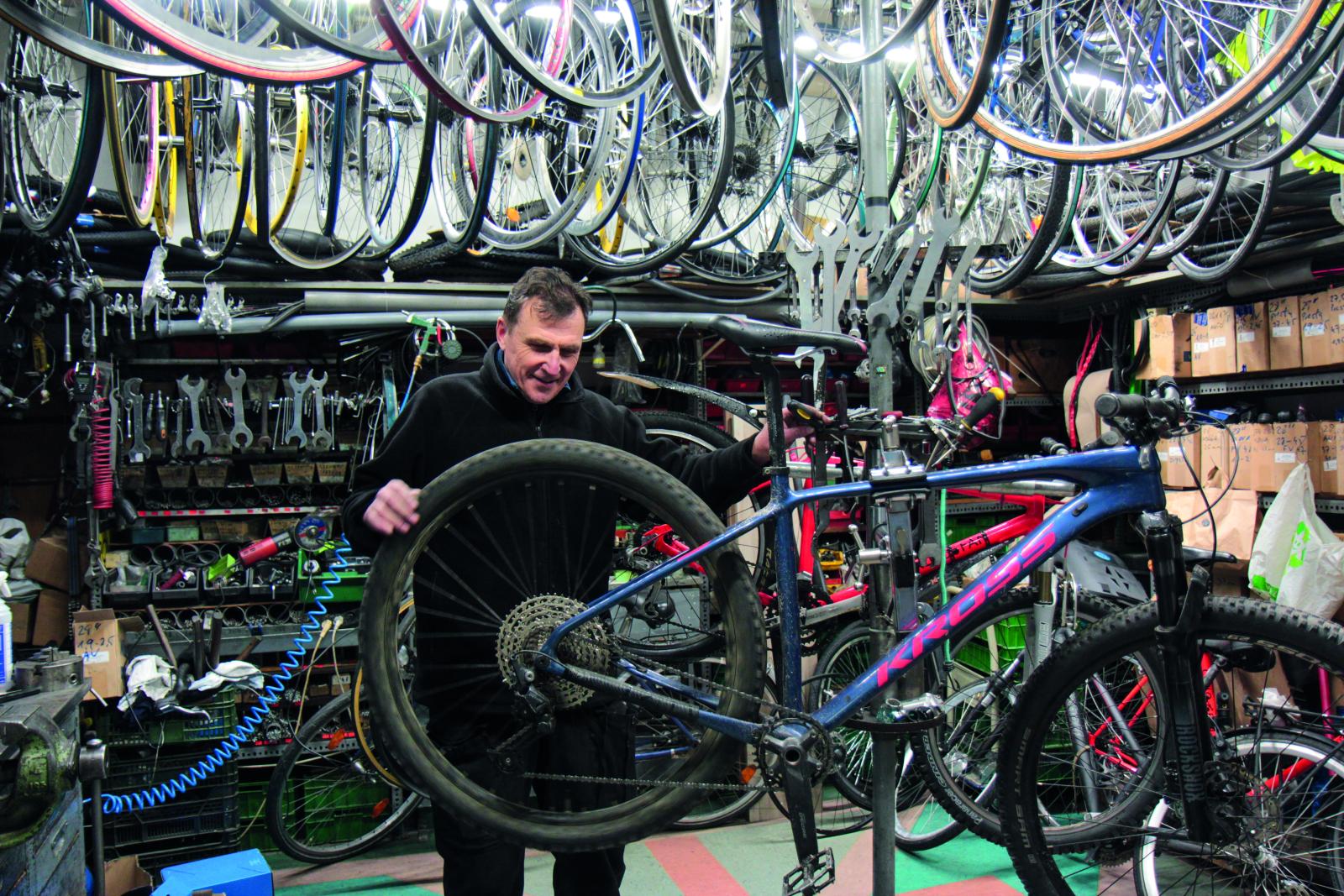 Mężczyzna naprawia rower w serwisie rowerowym