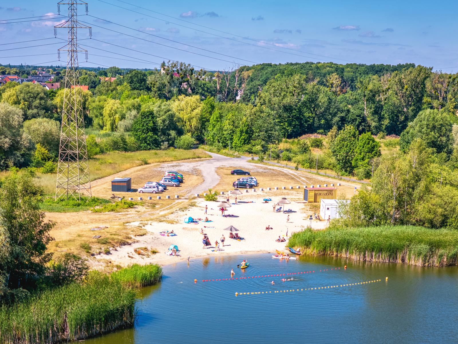 Zdjęcie przedstawia widok na kąpielisko Malina, z góry. Widac plażę i ludzi kąpiących się
