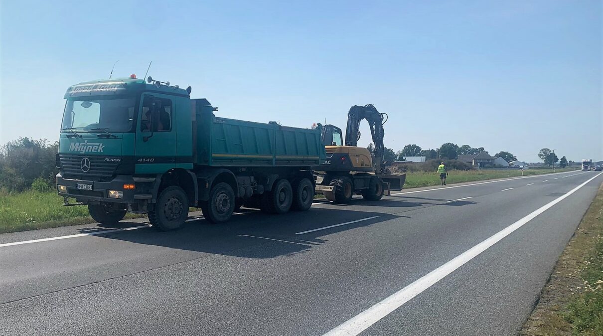 Duży samochód cieżarowy razem z koparką na drodze