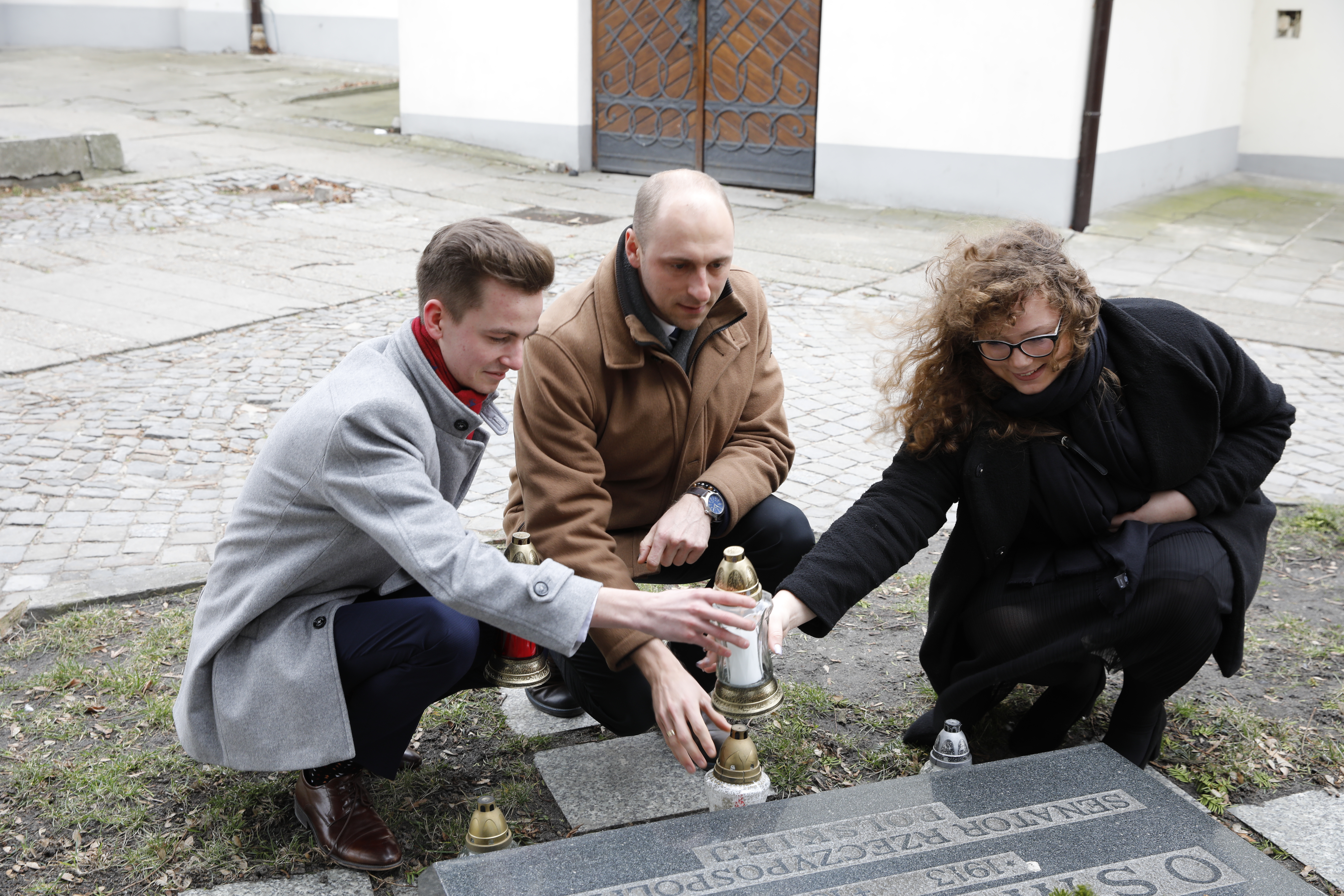 Przewodniczący Łukasz Sowada z przedstawicielami Młodzieżowej Rady Miasta na jednym z grobów