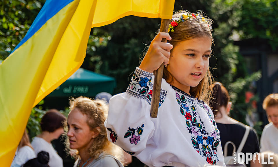 zdjęcie dziewczynki w ludowym stroju z ukraińską flagą
