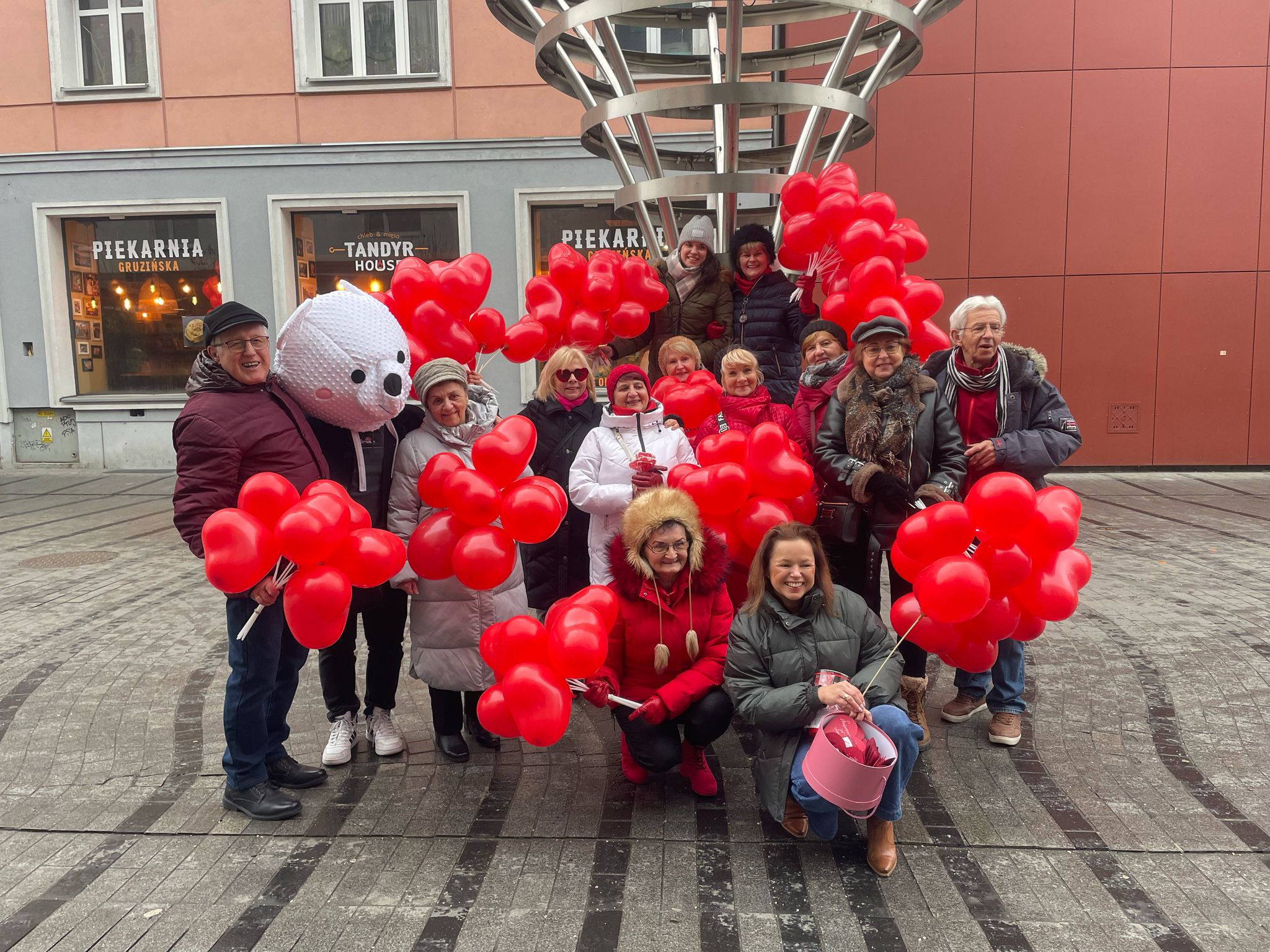 zdjęcie seniorów z czerwonymi balonami