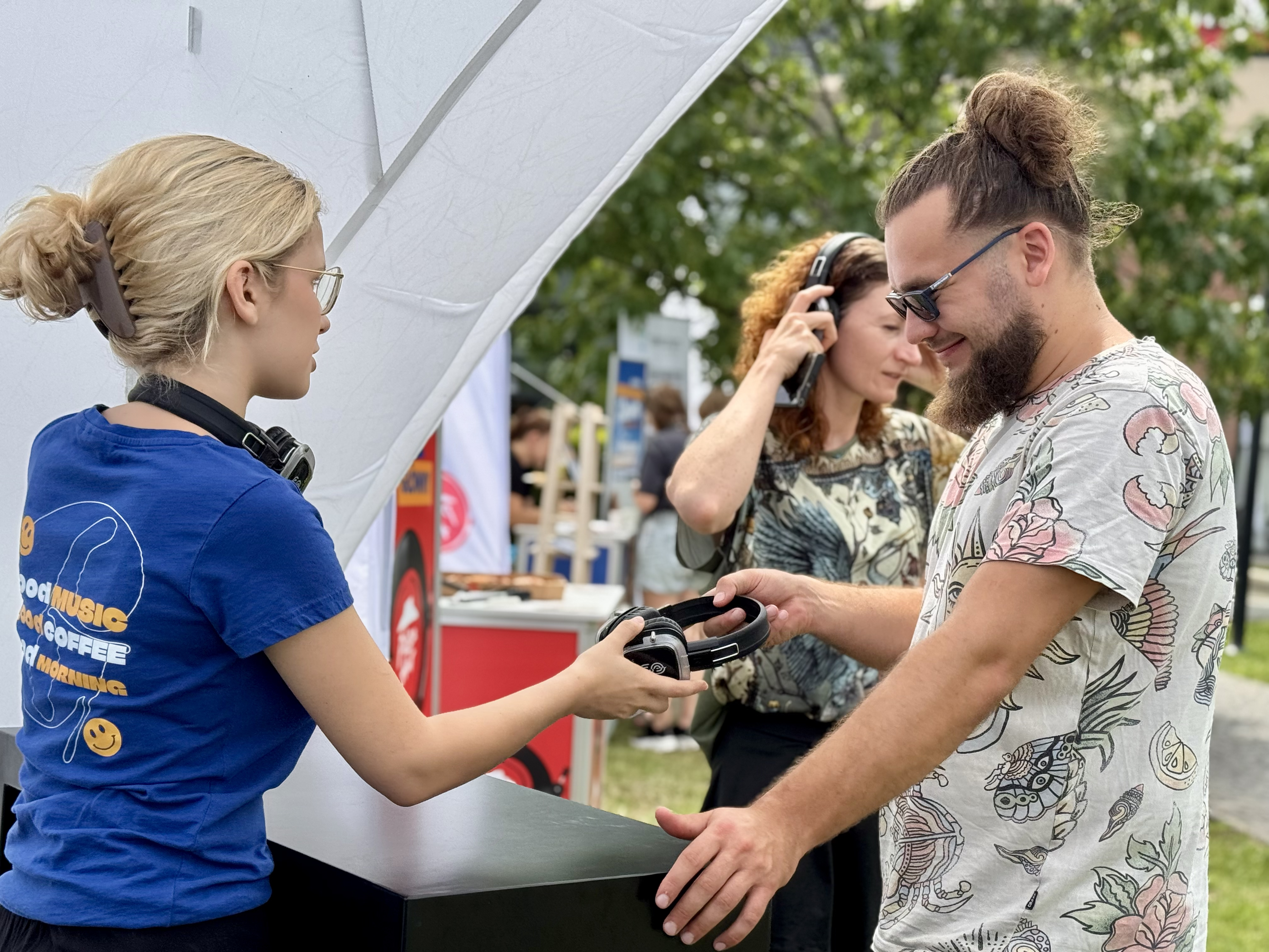 kobieta podająca mężczyxnie słuchawki