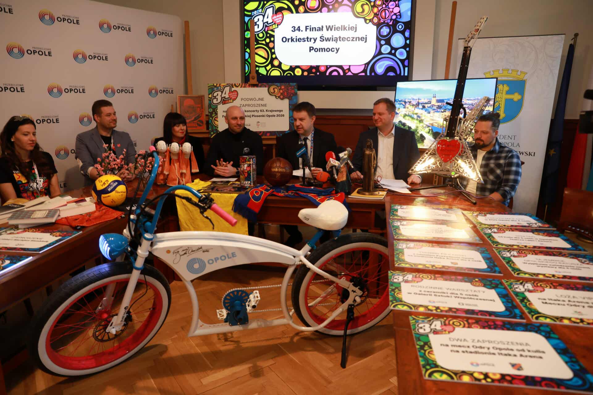 konferencja prasowa, przedmioty na licytacje WOŚP, mikrofony, osoby