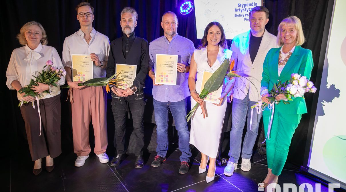 grupa stypendystów stojących w rzędzie z tytułami