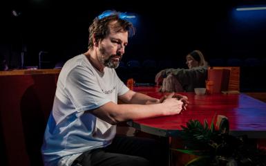 Zdjęcie przedstawia mężczyznę, aktorta podczas spektaklu