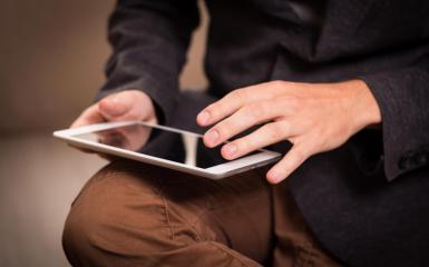 Osoba trzymająca tablet w dłoni 