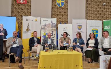 Panel dyskusyjny: grupa sześciu osób siedzi na środku sali.