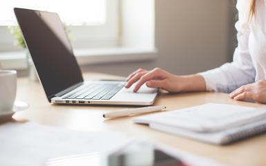 dłoń pracująca na laptopie