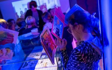 Zdjęcie przedstawia dzieci zwiedzające wystawe w bibliotece