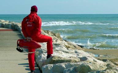 ratownik medyczny stojący nad brzegiem morza