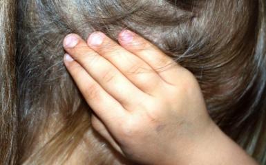 dziewczynka zasłaniająca uszy