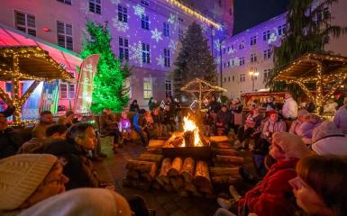 Ludzie siedzący przy ognisku na jarmarku w Opolu