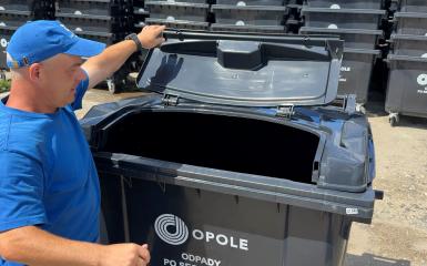 mężczyzna otwierający pojemnik na odpady