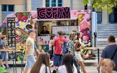 osoby idące przez miasto, napis gofry