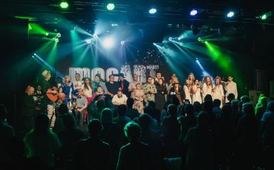 Zdjęcie z koncertu- widok na scenę. Tłum ludzi. Sala koncertowa