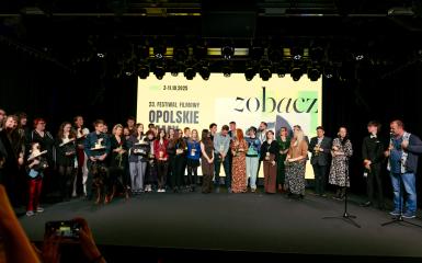Zdjęcie przedstawia scene. Jest na niej bardzo duża grupa ludzi. 