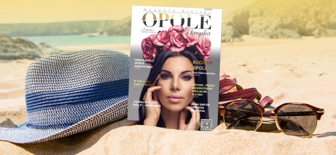 Archiwalny nymer Opole i kropka z 2026 roku na plaży. Obok kapelusza oraz okularów przeciwsłonecznych. 