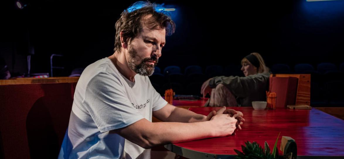 Zdjęcie przedstawia mężczyznę, aktorta podczas spektaklu