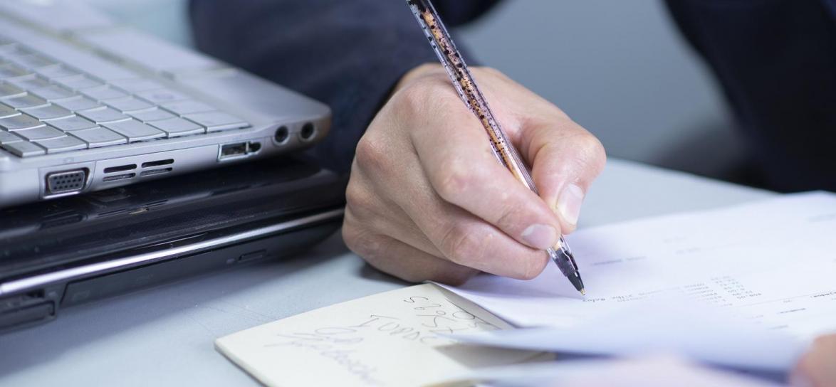 Osoba pisząca na kartce