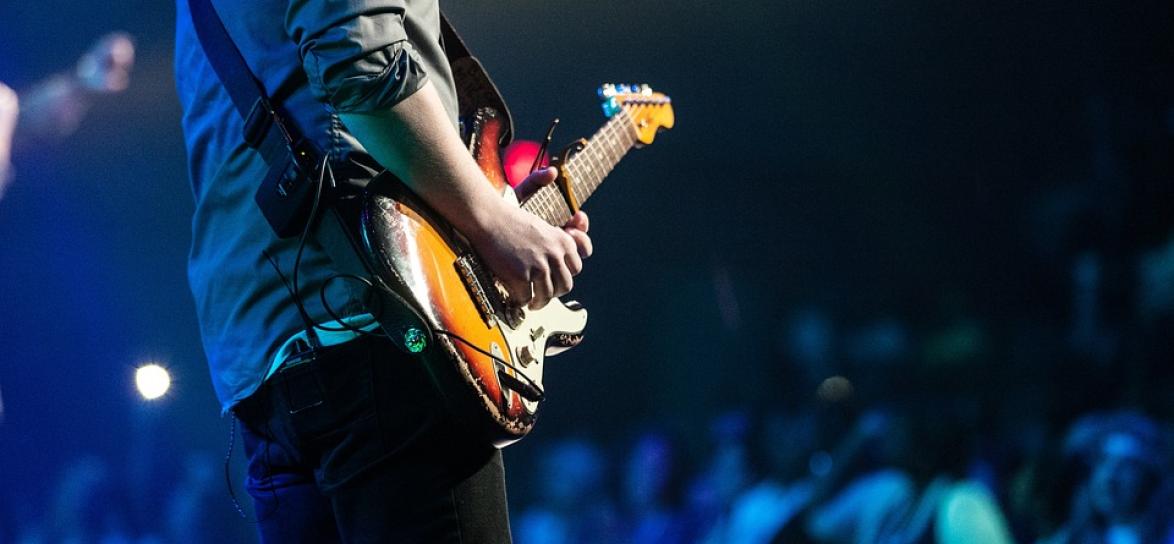zdjęcie z koncertu, mężczyzna gra na gitarze elektrycznej