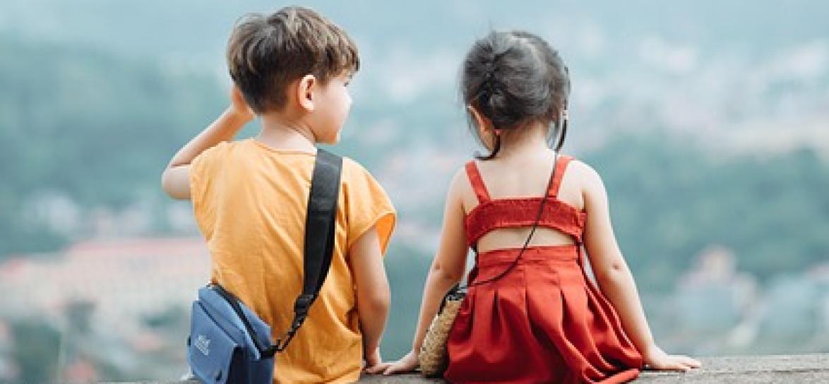 dwójka dzieci siedzących tyłem