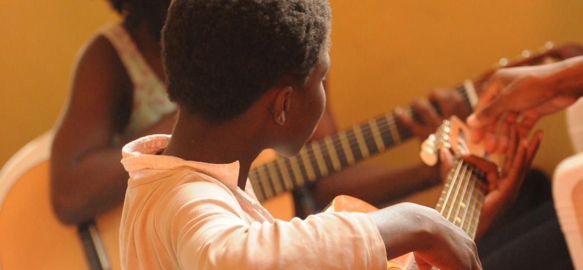 zdjęcie przedstawiające chłopca grającego na gitarze