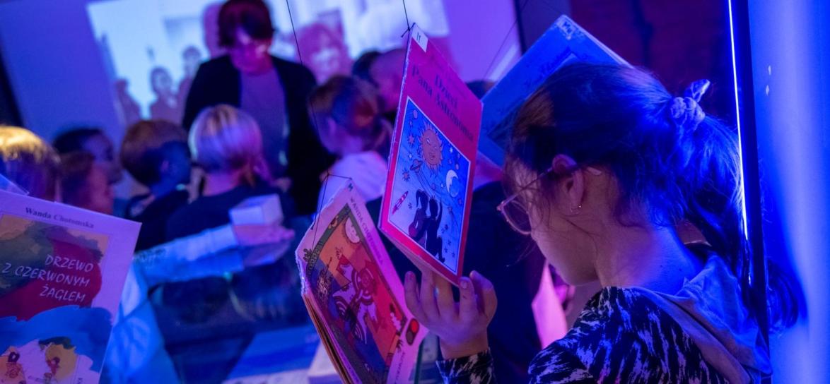 Zdjęcie przedstawia dzieci zwiedzające wystawe w bibliotece
