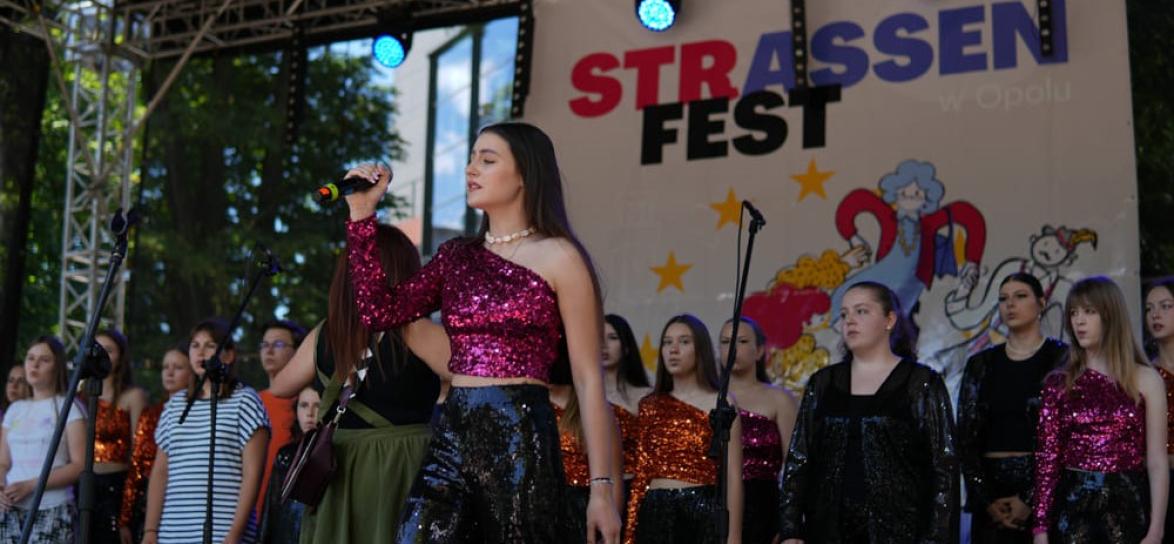 biała kobieta, trzyma mikrofon, śpiewa na scenie