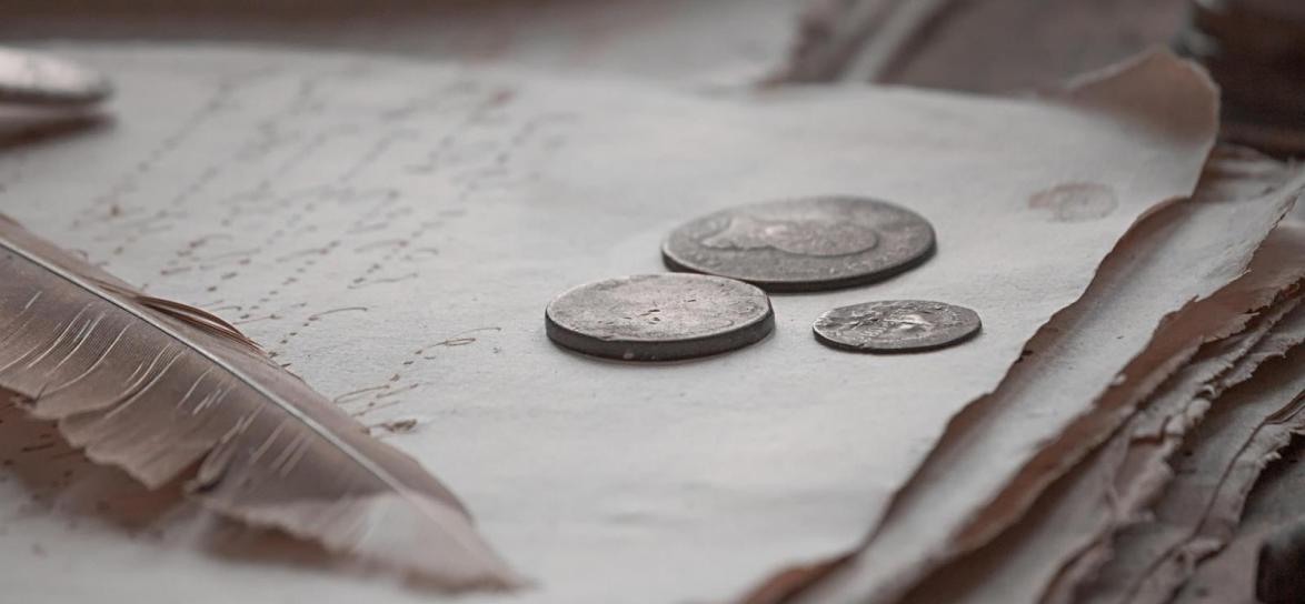 trzy monety położone na stercie białych kartek, fot. pixabay