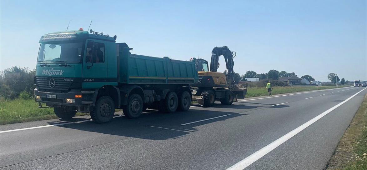 Duży samochód cieżarowy razem z koparką na drodze
