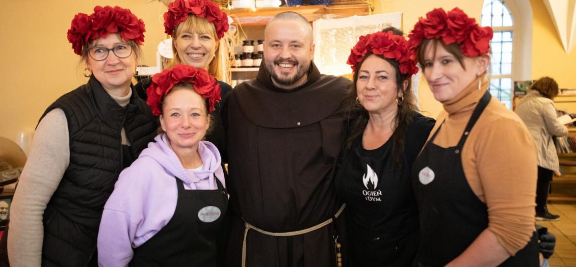 zdjęcie franciszkanina z gośćmi jarmarku