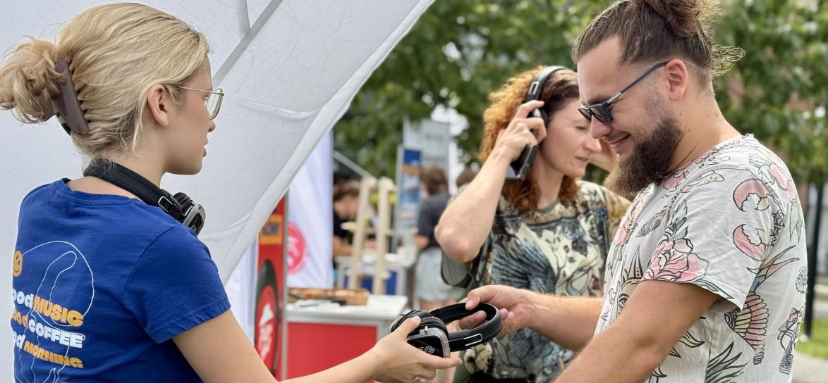 kobieta podająca mężczyxnie słuchawki