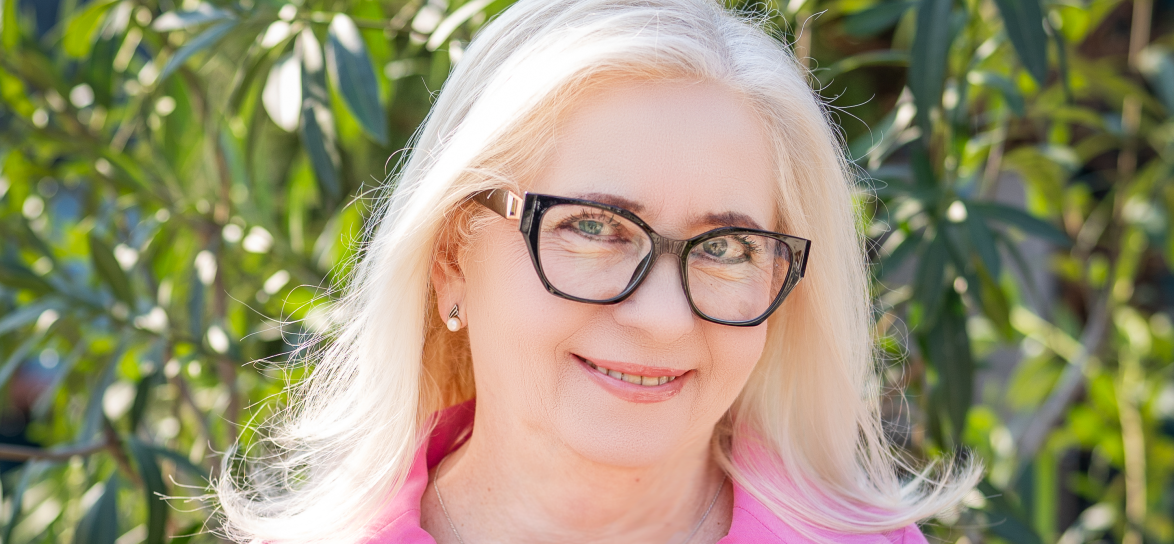 postać pani dyrektor, kobieta w okularach i różowej sukience