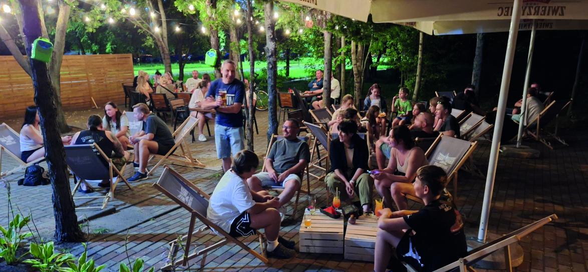 osoby siedzą na leżakach