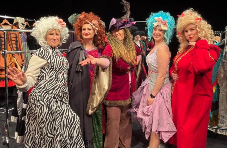 pięc białych kobiet przebranych w stroje sceniczny teatru, na głowach peruki, jedna ma kapelusz na głowie