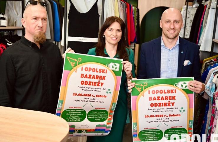 Dwóch białych mężczyzn, w środku białą kobieta, trzymają plakatu zapowiadające wydarzenie