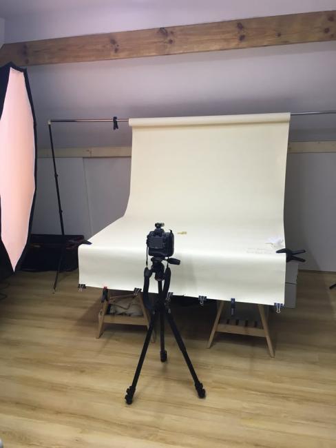 Zdjecie przestawia pracownię fotograficzną. Widok na aparat fotograficzny i stół bezcieniowy
