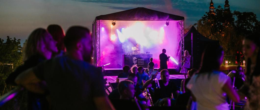 osoby na tle sceny wieczorową porą