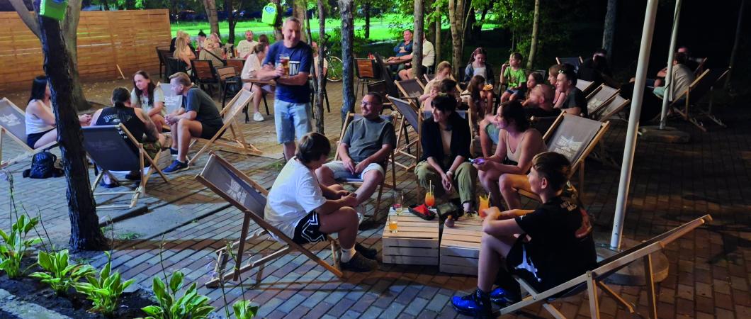osoby siedzą na leżakach