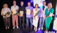grupa stypendystów stojących w rzędzie z tytułami