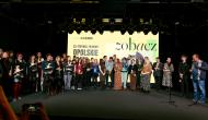 Zdjęcie przedstawia scene. Jest na niej bardzo duża grupa ludzi. 